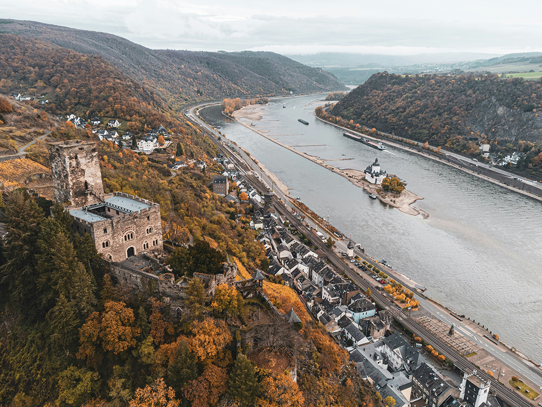 Panoramski pogled na mesto Kaub ob Renu, grad Gutenfels in grad Pfalzgrafenstein na otoku sredi reke.