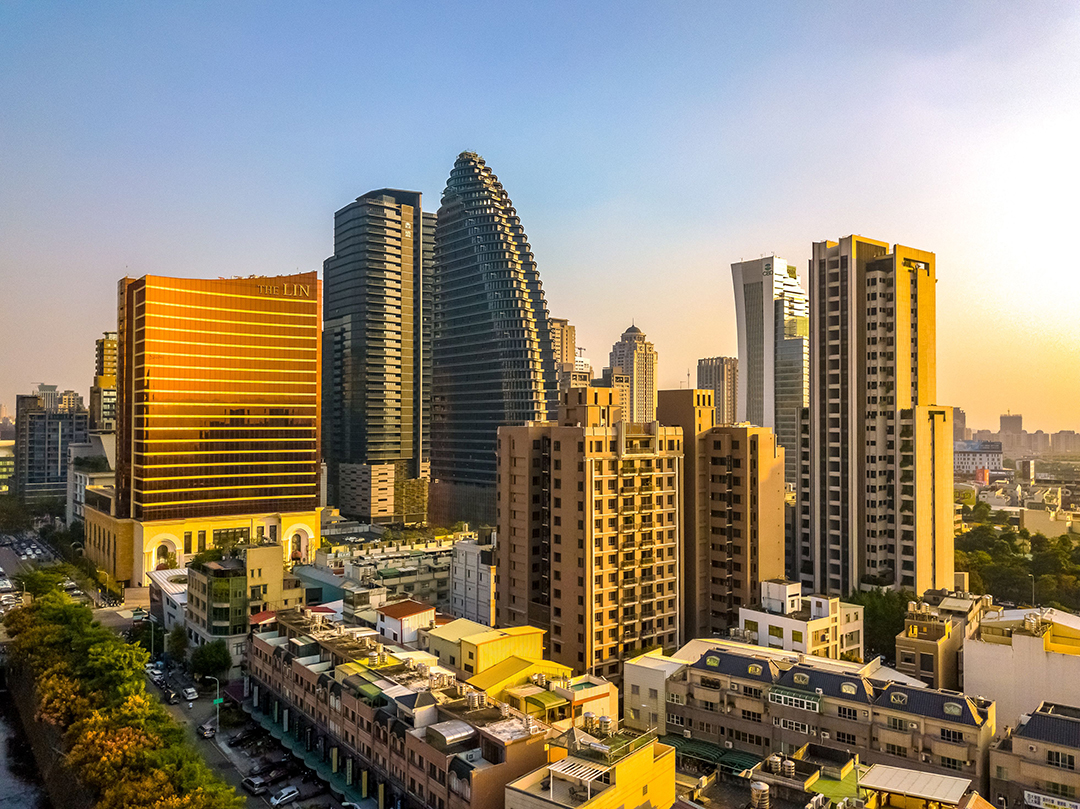 Modern high-rise buildings and the city skyline of Taichung, Taiwan, illuminated by golden evening light.